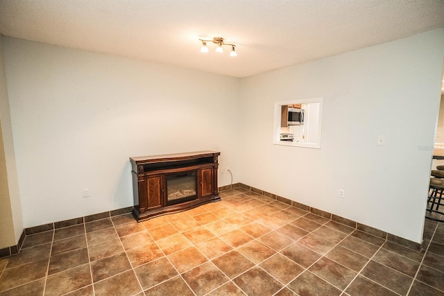 washroom featuring dark tile patterned flooring and a textured ceiling