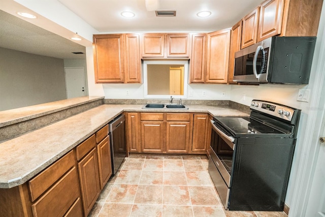 kitchen with sink, kitchen peninsula, stainless steel appliances, and light tile patterned floors