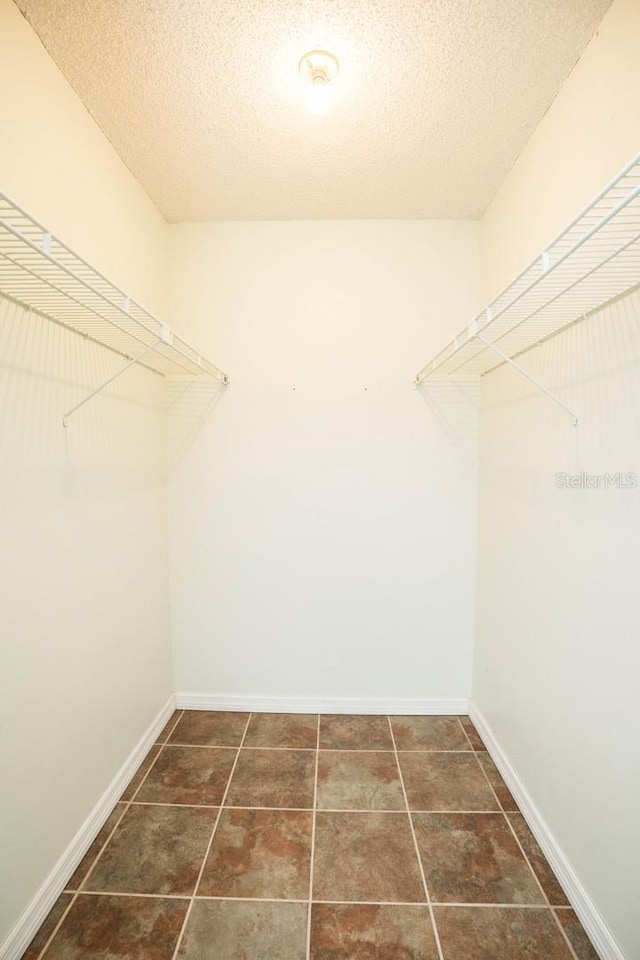 spacious closet with dark tile patterned floors