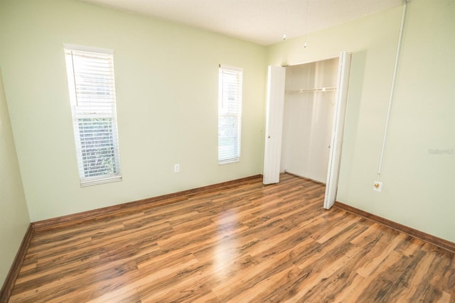 unfurnished bedroom with hardwood / wood-style flooring and a closet