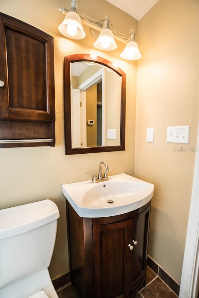 bathroom featuring tile patterned flooring, vanity, and toilet