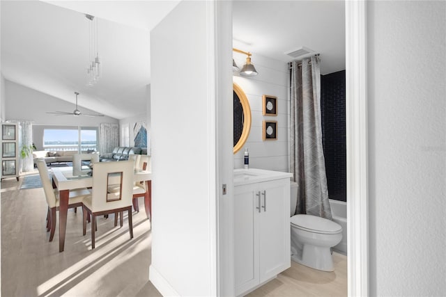 full bathroom featuring vanity, vaulted ceiling, ceiling fan, shower / tub combo with curtain, and toilet