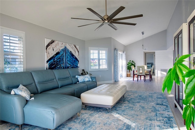 living room with hardwood / wood-style flooring, plenty of natural light, and vaulted ceiling