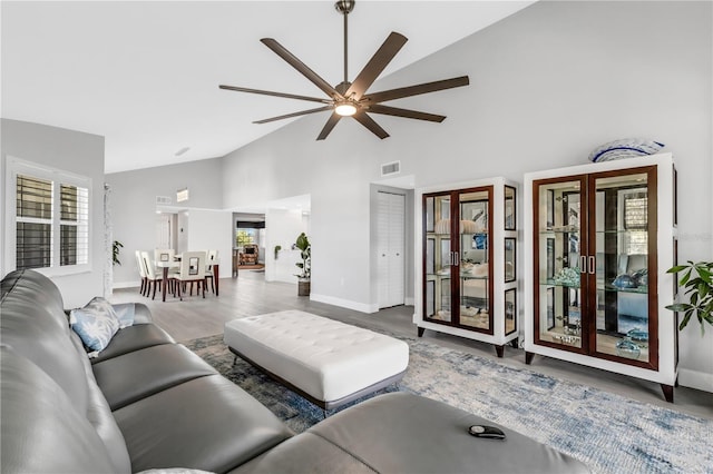 living room featuring hardwood / wood-style flooring, high vaulted ceiling, ceiling fan, and a healthy amount of sunlight