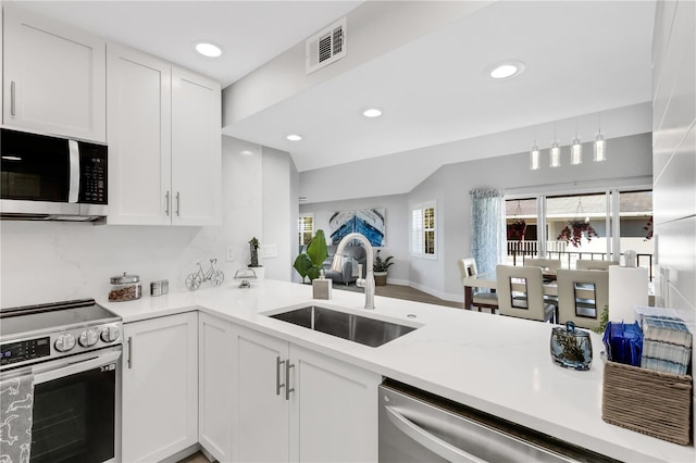 kitchen featuring appliances with stainless steel finishes, backsplash, white cabinetry, and sink