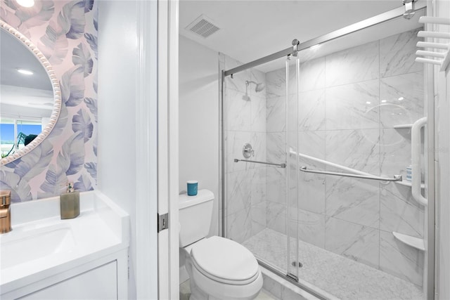 bathroom featuring vanity, an enclosed shower, and toilet