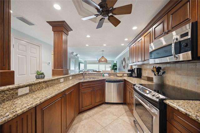 6140 Midnight Pass Rd Unit 407, Sarasota, FL 34242 - kitchen featuring kitchen peninsula, sink, appliances with stainless steel finishes, light stone counters, and ornate columns