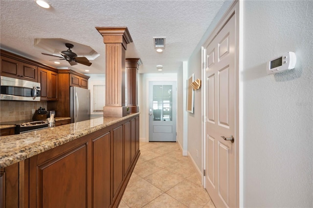 6140 Midnight Pass Rd Unit 407, Sarasota, FL 34242 - kitchen with decorative columns, stainless steel appliances, backsplash, light tile patterned flooring, and light stone countertops