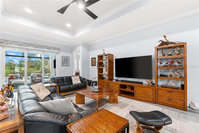 living room with a raised ceiling, ceiling fan, hardwood / wood-style floors, and ornamental molding