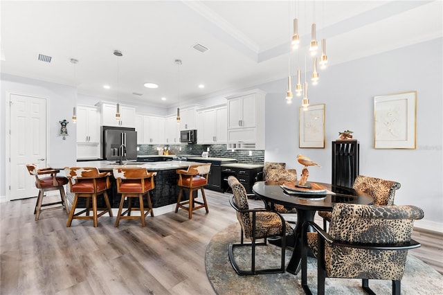 dining room featuring light hardwood / wood-style floors and ornamental molding