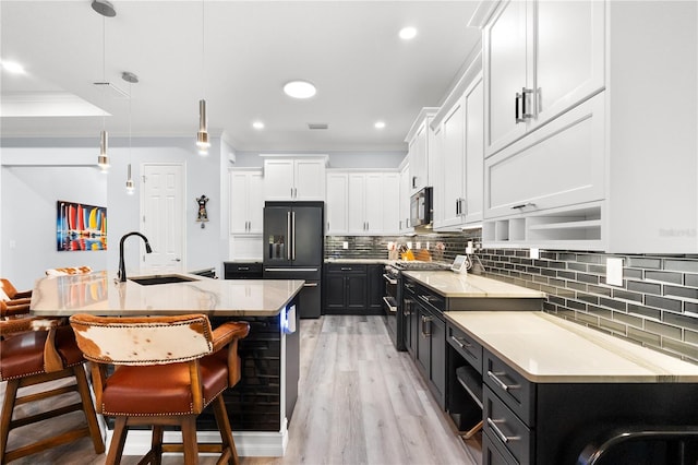 kitchen featuring black appliances, a spacious island, sink, hanging light fixtures, and white cabinetry