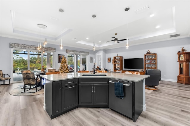 kitchen featuring a center island with sink, a raised ceiling, and stainless steel dishwasher