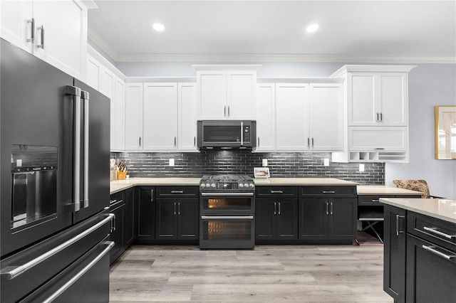 kitchen with white cabinets, light hardwood / wood-style floors, ornamental molding, and appliances with stainless steel finishes