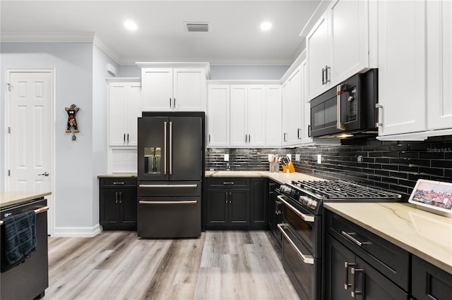 kitchen featuring white cabinetry, light hardwood / wood-style flooring, crown molding, and black appliances