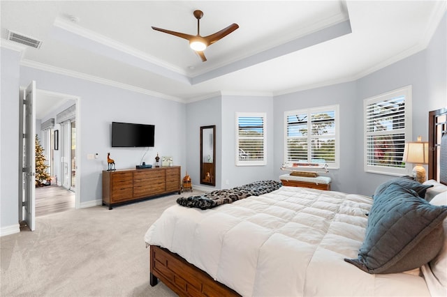 carpeted bedroom featuring ceiling fan, crown molding, and a tray ceiling