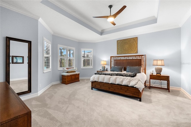 bedroom featuring light colored carpet, a raised ceiling, ceiling fan, and crown molding