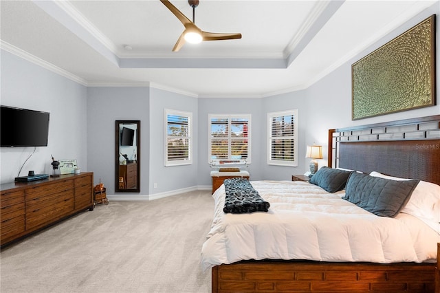 bedroom featuring light carpet, a tray ceiling, ceiling fan, and ornamental molding