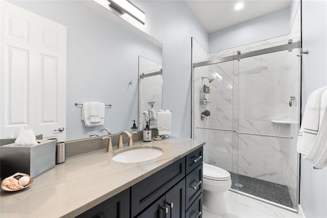 bathroom featuring vanity, toilet, and a shower with door