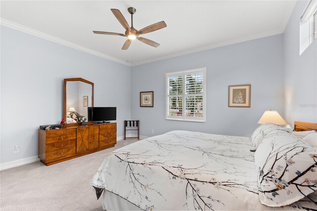 carpeted bedroom with ceiling fan and ornamental molding