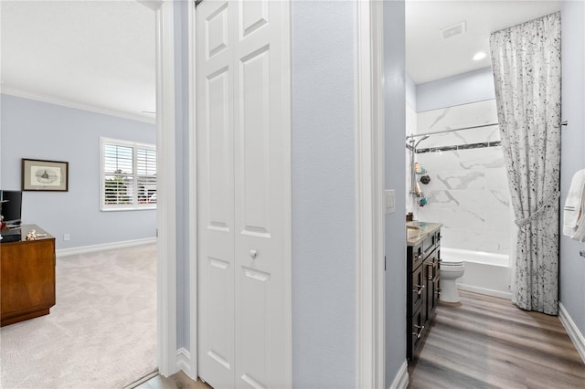 corridor featuring light wood-type flooring and crown molding