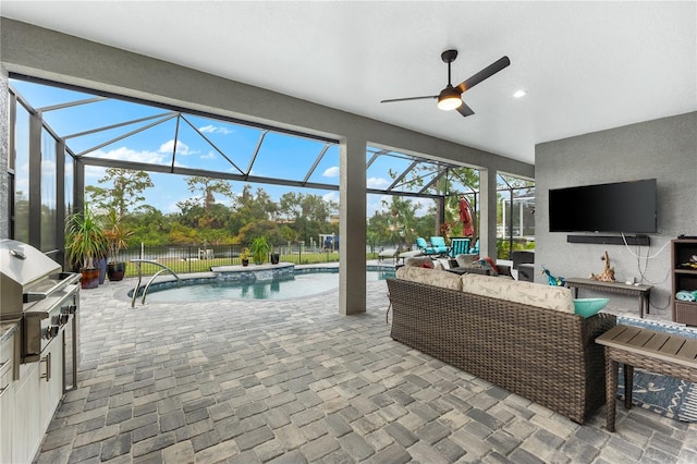 view of patio featuring an outdoor kitchen, ceiling fan, an outdoor living space, and glass enclosure