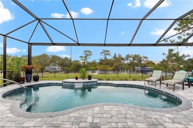 view of pool with glass enclosure and a patio area