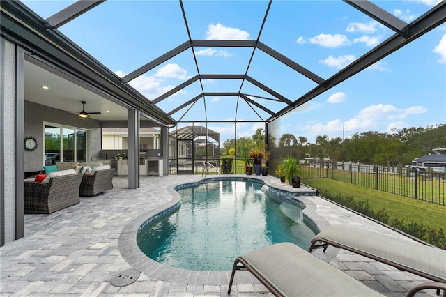 view of swimming pool with an outdoor living space, ceiling fan, a lanai, a yard, and a patio area