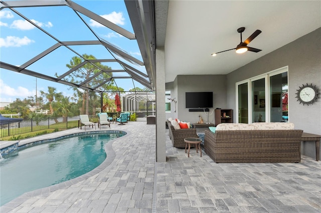 view of pool with a patio, an outdoor hangout area, glass enclosure, and ceiling fan