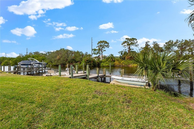 view of dock with a water view and a lawn