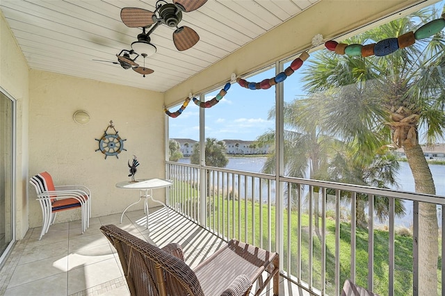 sunroom / solarium with ceiling fan, a water view, and wood ceiling