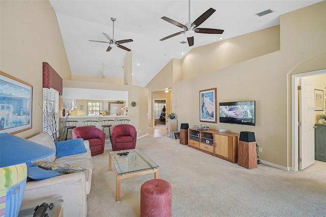 carpeted living room with high vaulted ceiling