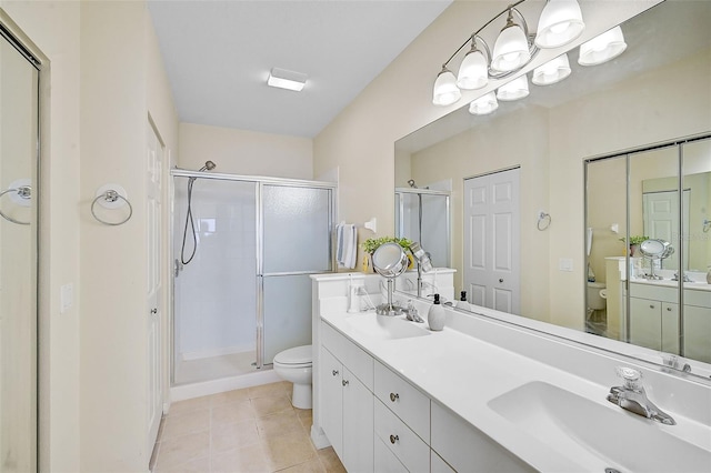 bathroom featuring tile patterned floors, vanity, toilet, and walk in shower