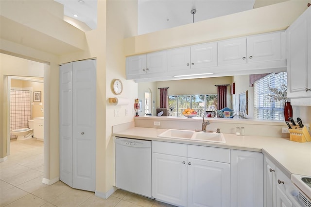 kitchen with white dishwasher, white cabinetry, and sink