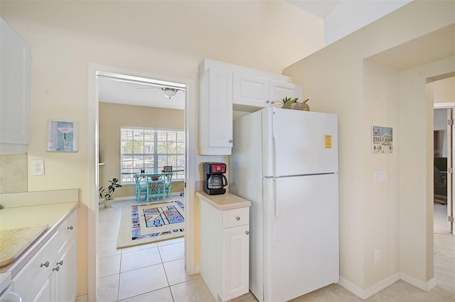 kitchen featuring ceiling fan, white cabinets, light tile patterned floors, and white refrigerator