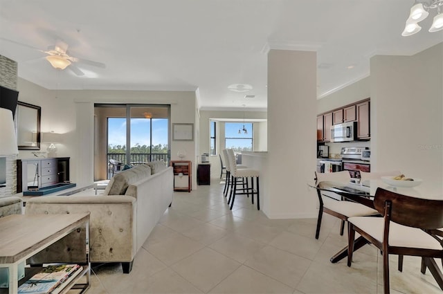 tiled living room featuring ceiling fan and crown molding