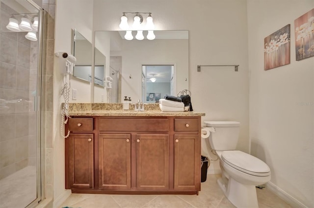 bathroom featuring tile patterned floors, vanity, toilet, and a shower with door