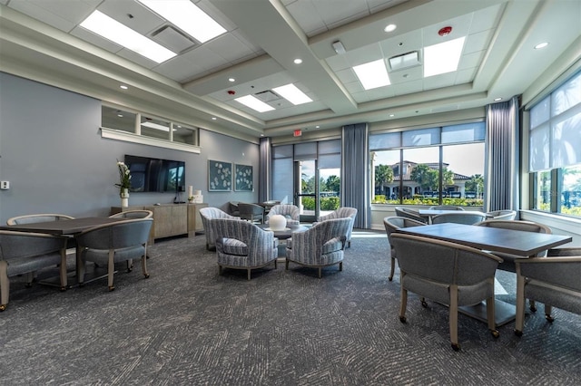 interior space featuring dark colored carpet, a raised ceiling, and plenty of natural light