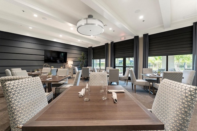 dining area with wood walls, beam ceiling, and carpet floors