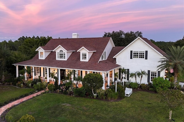 view of front of home with a porch and a yard