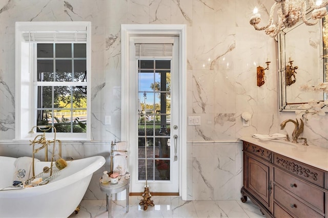 bathroom featuring a washtub, vanity, and tile walls