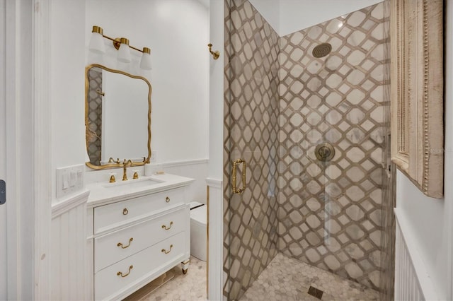 bathroom with a tile shower, vanity, toilet, and tile patterned floors