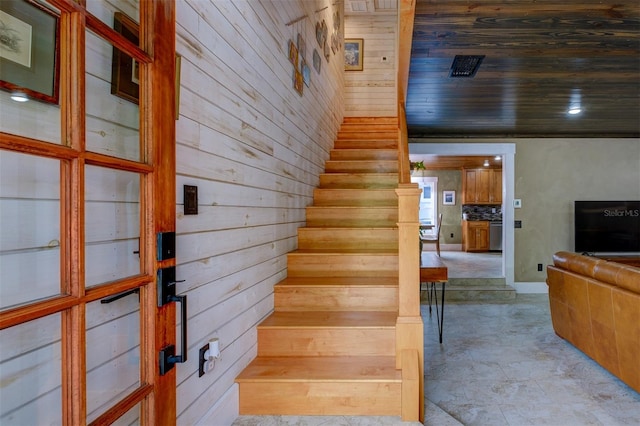 staircase featuring wooden walls and wood ceiling