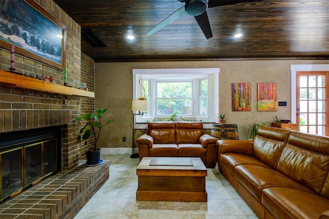 living room featuring ceiling fan, wooden ceiling, and a brick fireplace