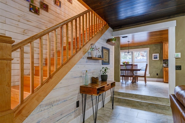 interior space featuring wood walls, wooden ceiling, and an inviting chandelier