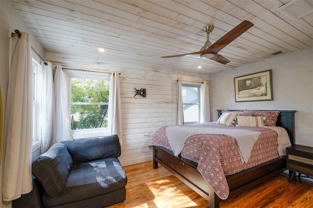 bedroom featuring wood-type flooring, ceiling fan, wooden ceiling, and wood walls