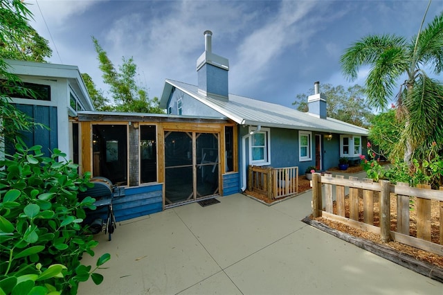 rear view of house with a patio area and a sunroom