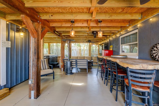 interior space with beam ceiling, ceiling fan, and concrete floors