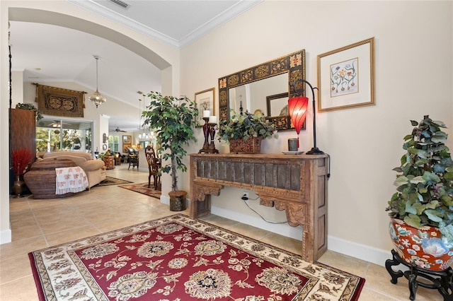 foyer entrance with tile patterned flooring, ceiling fan, crown molding, and vaulted ceiling