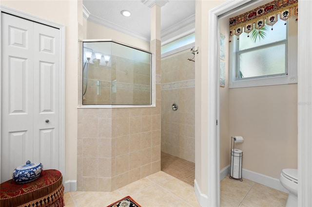 bathroom with tile patterned flooring, toilet, ornamental molding, and tiled shower