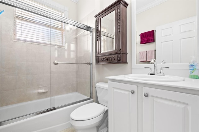 full bathroom featuring crown molding, vanity, enclosed tub / shower combo, and toilet